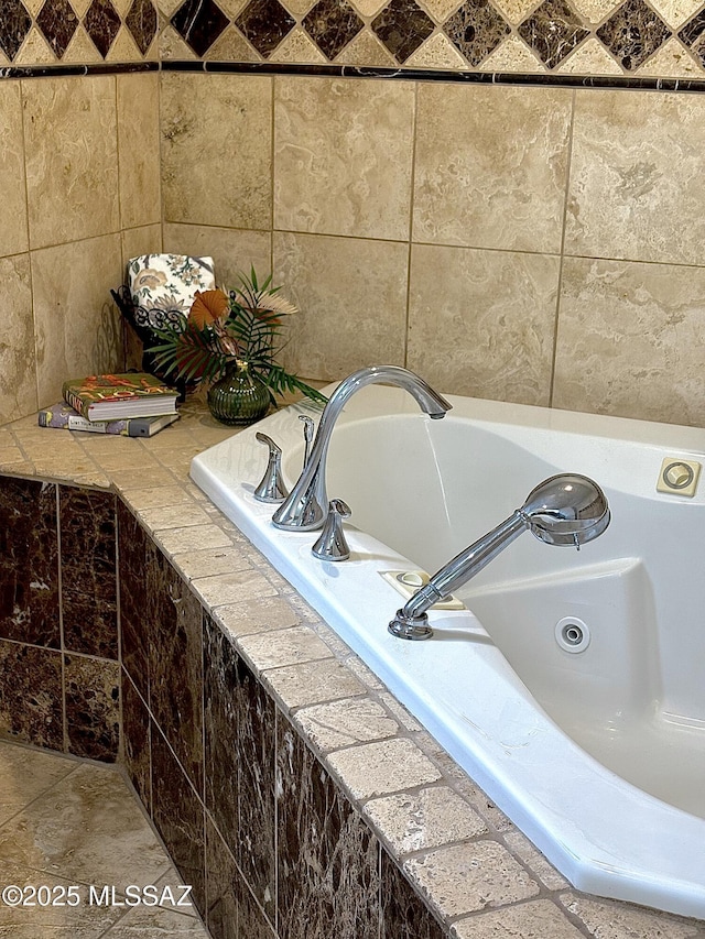 bathroom featuring tile patterned floors, tiled bath, and sink