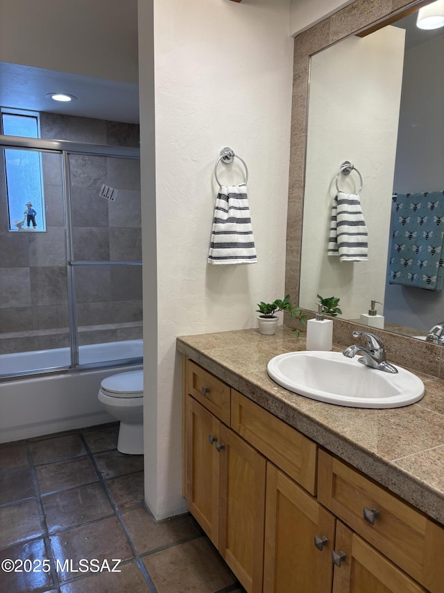 full bathroom featuring vanity, bath / shower combo with glass door, and toilet