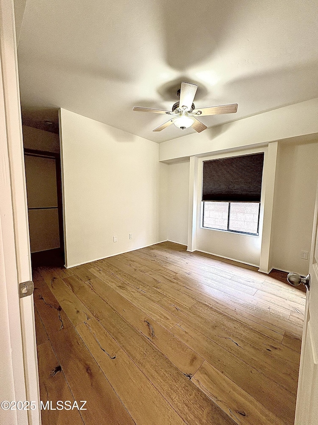 empty room with hardwood / wood-style flooring and ceiling fan