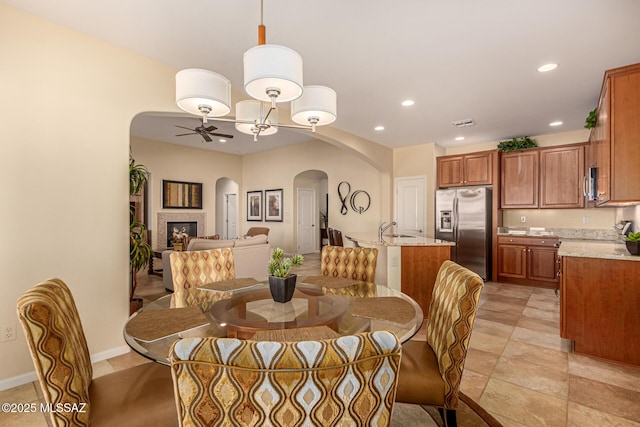 dining space with ceiling fan and sink