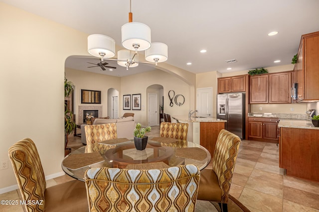 60782 E Arroyo Vista Dr, Oracle, AZ 85623 - dining area with a ceiling fan, recessed lighting, visible vents, arched walkways, and a fireplace