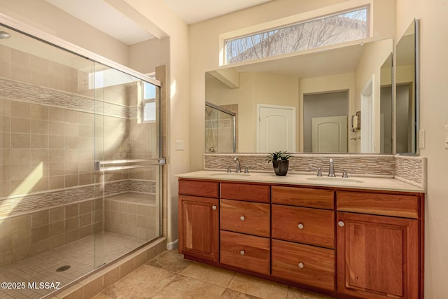 bathroom featuring vanity, a shower with door, and backsplash