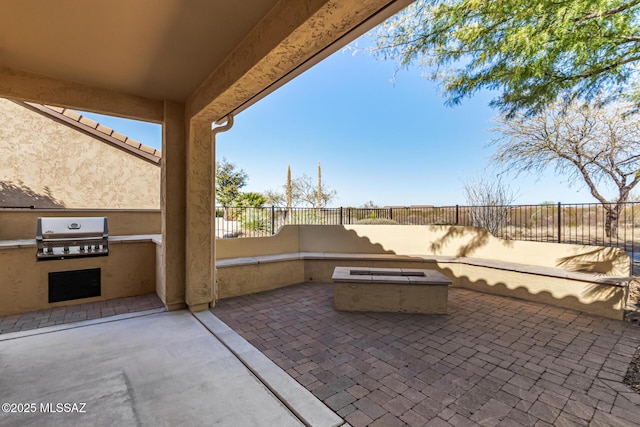 view of patio with exterior kitchen, grilling area, and an outdoor fire pit