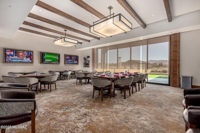 carpeted dining room with beam ceiling