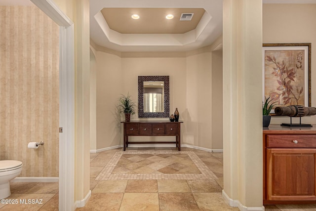 60782 E Arroyo Vista Dr, Oracle, AZ 85623 - hallway with a tray ceiling, arched walkways, baseboards, and visible vents