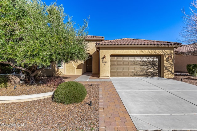60782 E Arroyo Vista Dr, Oracle, AZ 85623 - mediterranean / spanish-style home featuring an attached garage, concrete driveway, stucco siding, and a tile roof