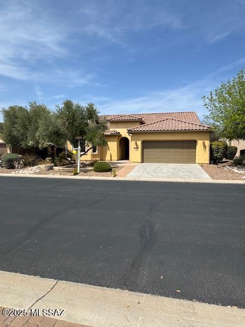 60782 E Arroyo Vista Dr, Oracle, AZ 85623 - mediterranean / spanish-style home with stucco siding, an attached garage, a tiled roof, and driveway