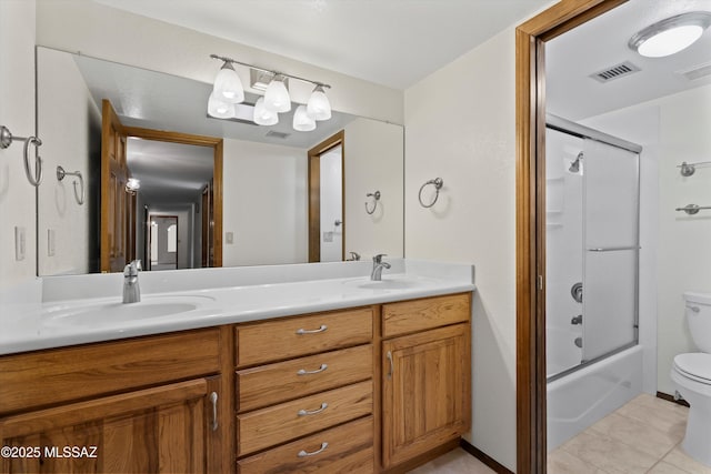 full bathroom featuring shower / bath combination with glass door, toilet, vanity, and tile patterned flooring