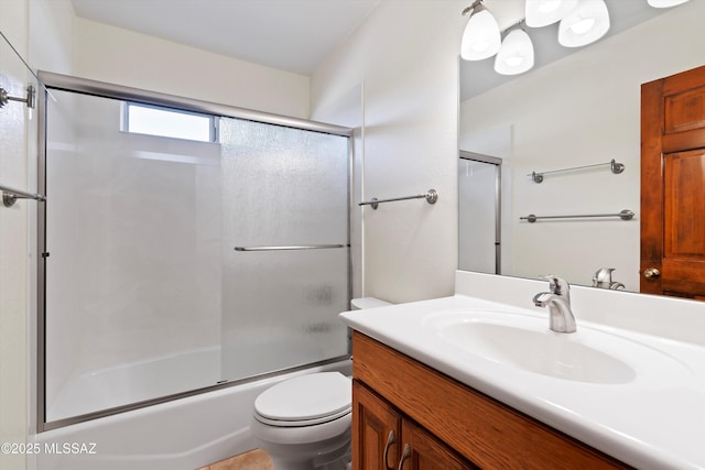 full bathroom featuring vanity, shower / bath combination with glass door, and toilet