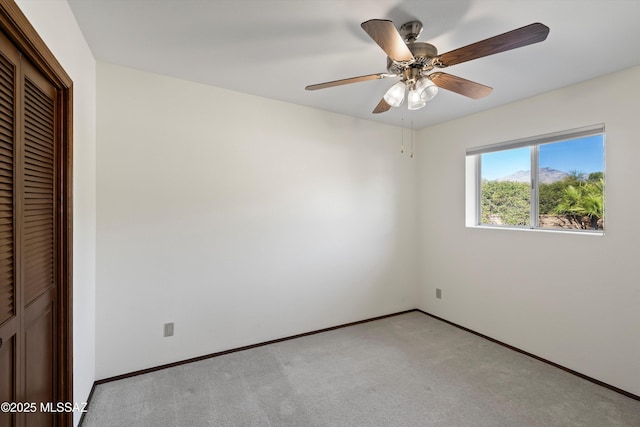 unfurnished bedroom featuring light carpet, a closet, and ceiling fan