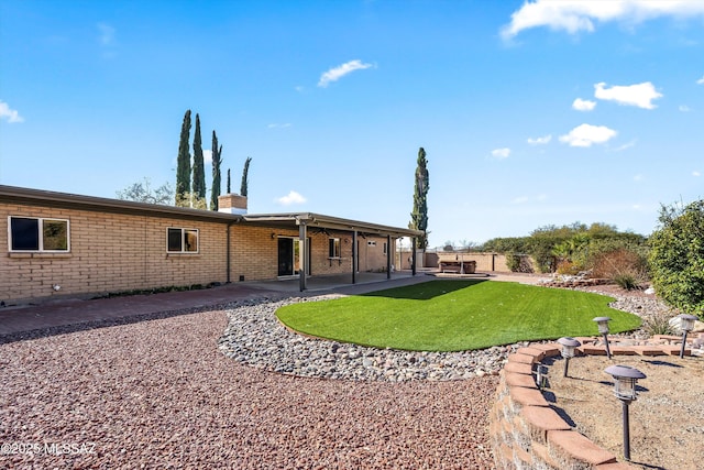 rear view of property with a patio and a yard