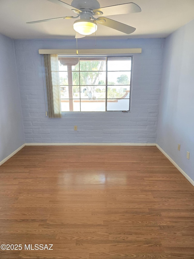 484 S La Canada Dr Unit B, Green Valley, AZ 85614 - spare room with hardwood / wood-style flooring, ceiling fan, and brick wall