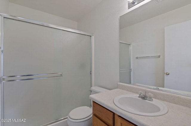 bathroom with toilet, vanity, and walk in shower