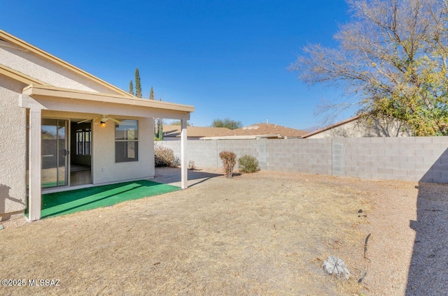 view of yard featuring ceiling fan and a patio