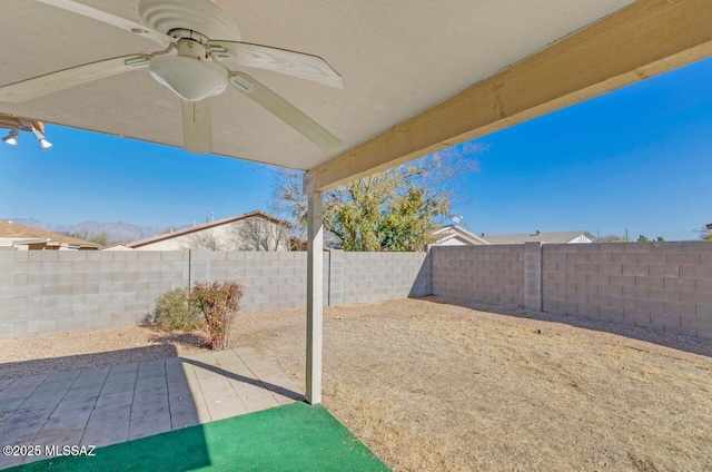 view of yard with ceiling fan and a patio