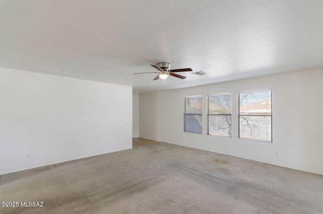 spare room featuring light carpet and ceiling fan