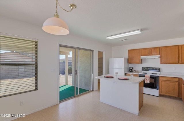 kitchen with decorative light fixtures, white appliances, and a center island