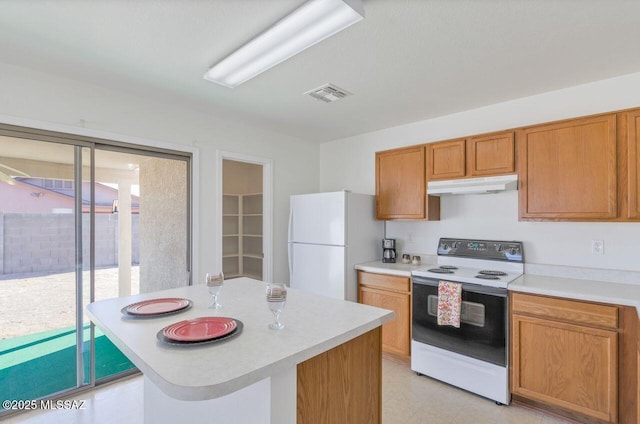 kitchen with white appliances, a breakfast bar area, and a center island