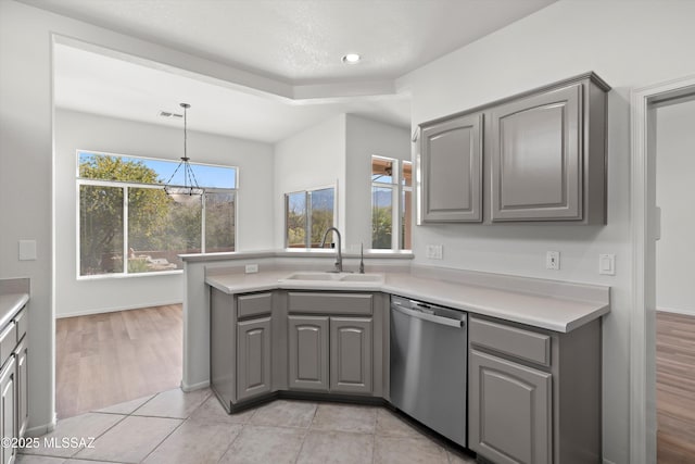 kitchen with visible vents, gray cabinets, stainless steel dishwasher, an inviting chandelier, and a sink