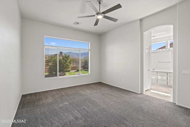 spare room featuring visible vents, baseboards, carpet, and a ceiling fan