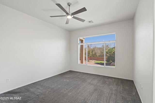 empty room featuring ceiling fan, visible vents, dark colored carpet, and baseboards