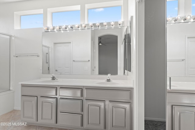 full bath featuring double vanity, ceiling fan, and a sink