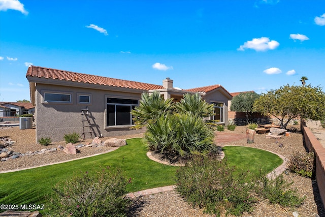 back of property featuring a tile roof, a yard, a chimney, and stucco siding