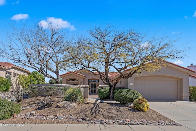 view of front facade featuring stucco siding, concrete driveway, an attached garage, and a tiled roof