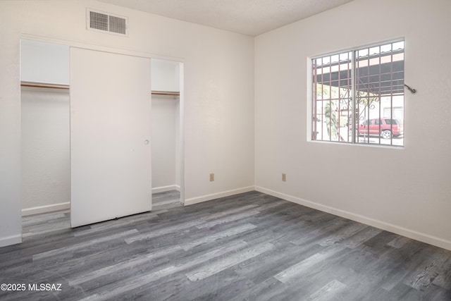 unfurnished bedroom featuring dark hardwood / wood-style floors and a closet