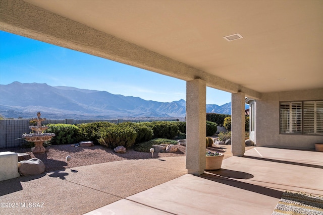 view of patio / terrace featuring a mountain view and fence