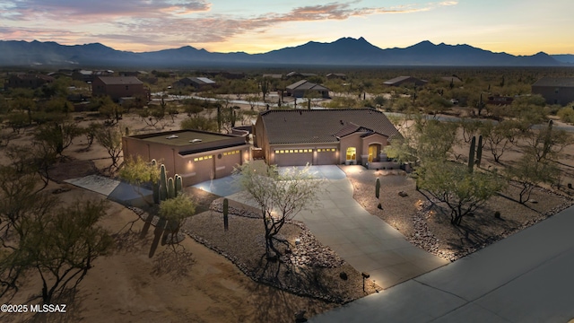 aerial view at dusk featuring a mountain view