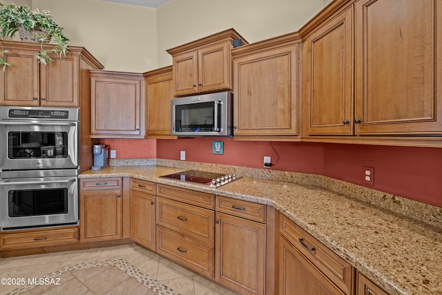 kitchen featuring light stone counters, light tile patterned floors, and appliances with stainless steel finishes