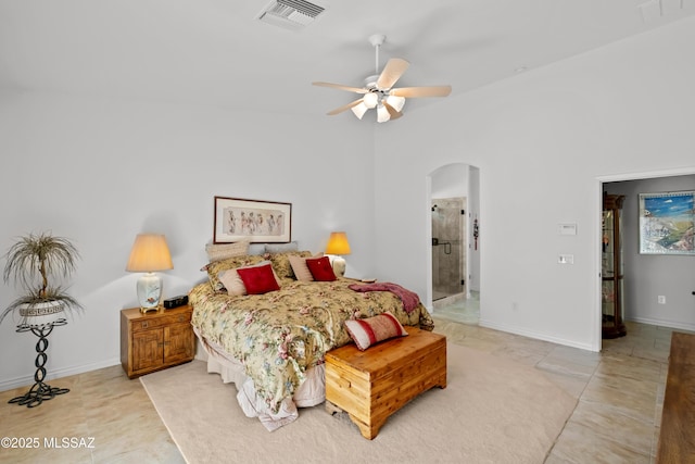 tiled bedroom featuring ceiling fan and ensuite bath