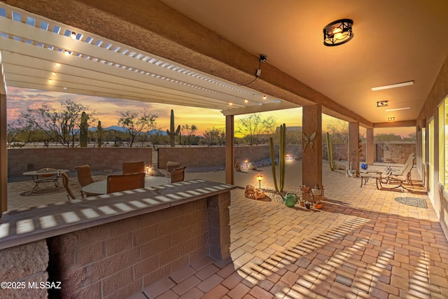 patio terrace at dusk featuring a pergola