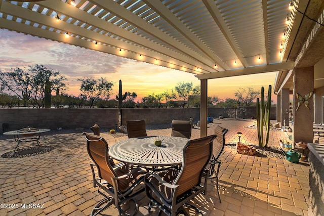 patio terrace at dusk featuring a pergola