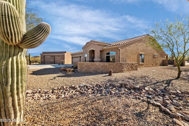 3534 E Sweet Grass Trl, Sahuarita, AZ 85629 - rear view of house with an attached garage, concrete driveway, stucco siding, and a tile roof