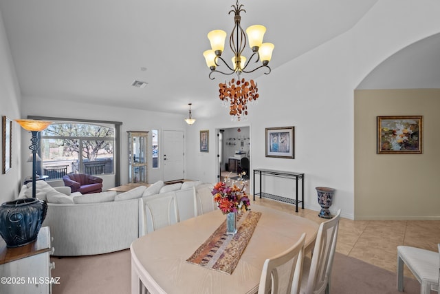 dining space with light tile patterned floors and a notable chandelier