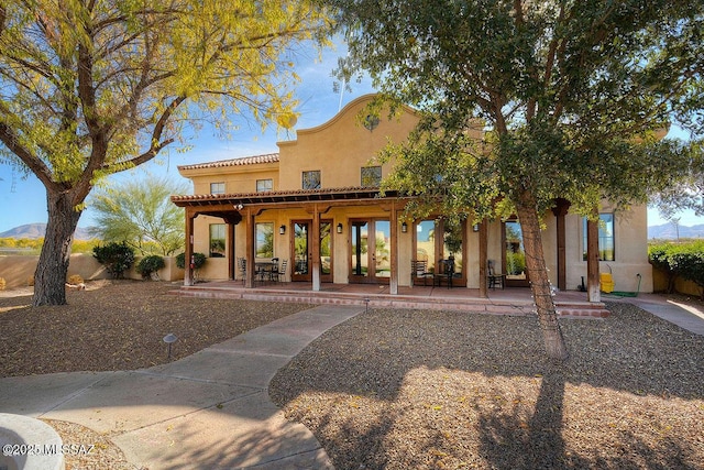 view of front facade featuring a mountain view, a pergola, and a patio area