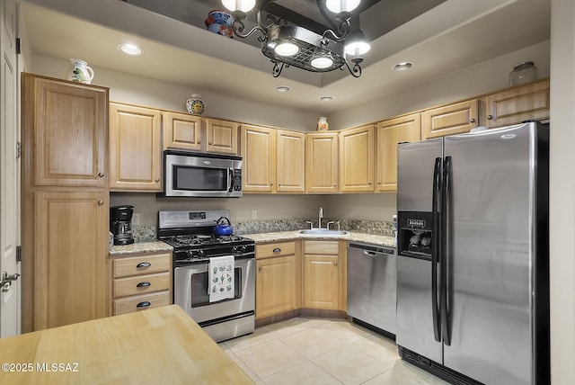 kitchen with light brown cabinetry, sink, light tile patterned flooring, and appliances with stainless steel finishes