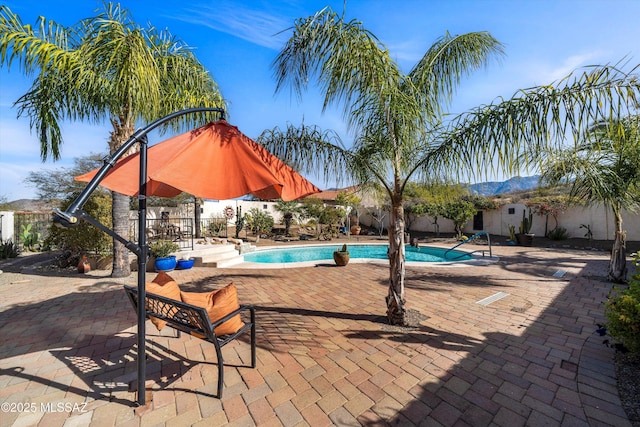 view of swimming pool featuring a mountain view and a patio