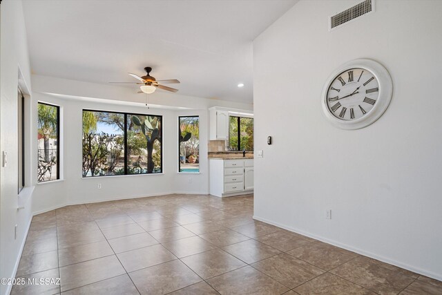 tiled empty room with ceiling fan