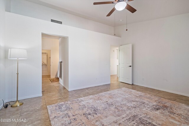 spare room with ceiling fan and a high ceiling