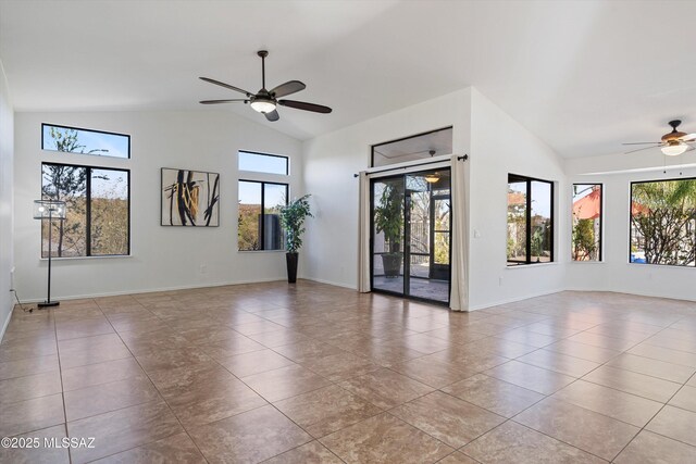 empty room featuring vaulted ceiling, plenty of natural light, light tile patterned floors, and ceiling fan