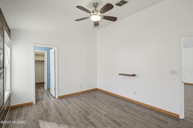 unfurnished bedroom featuring ceiling fan, wood-type flooring, a spacious closet, and a closet