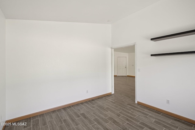 unfurnished room with dark wood-type flooring