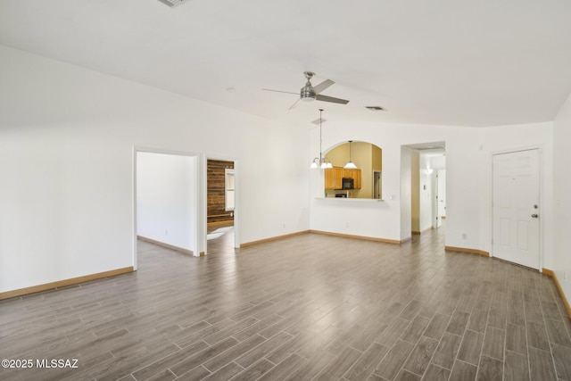 unfurnished living room with ceiling fan, lofted ceiling, and dark hardwood / wood-style flooring