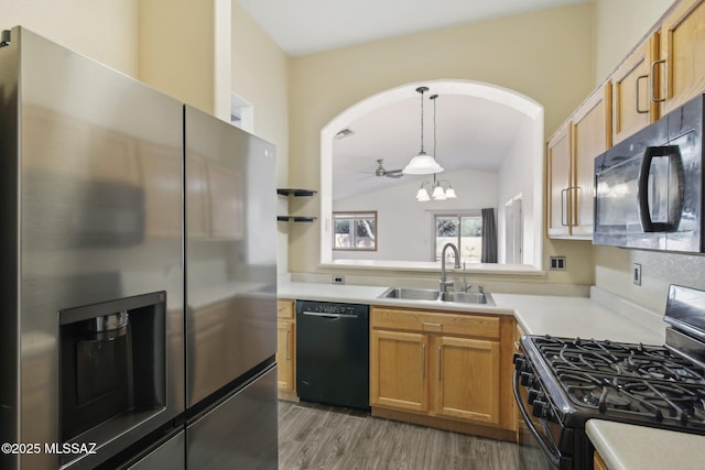 kitchen with dark wood-type flooring, sink, decorative light fixtures, vaulted ceiling, and black appliances