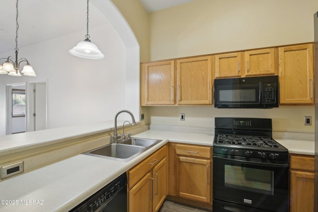 kitchen featuring pendant lighting, sink, black appliances, and kitchen peninsula