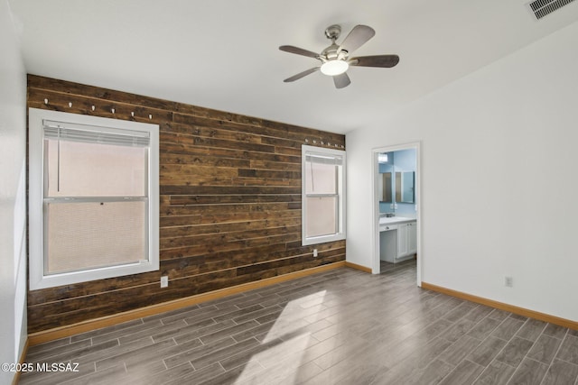 unfurnished room featuring dark wood-type flooring, ceiling fan, lofted ceiling, and wood walls