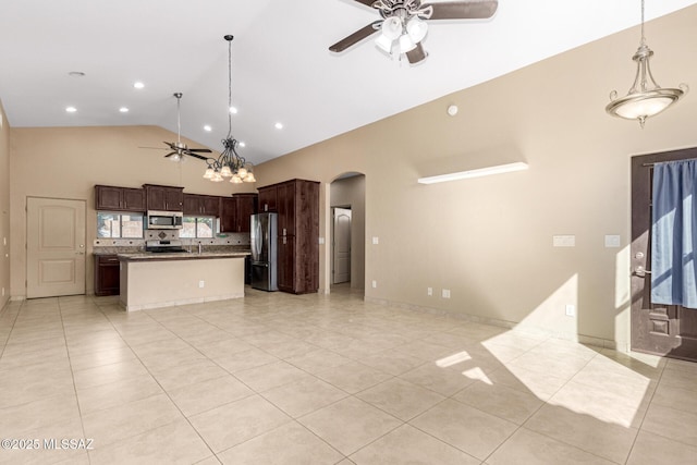 kitchen featuring decorative light fixtures, ceiling fan, backsplash, a center island, and appliances with stainless steel finishes